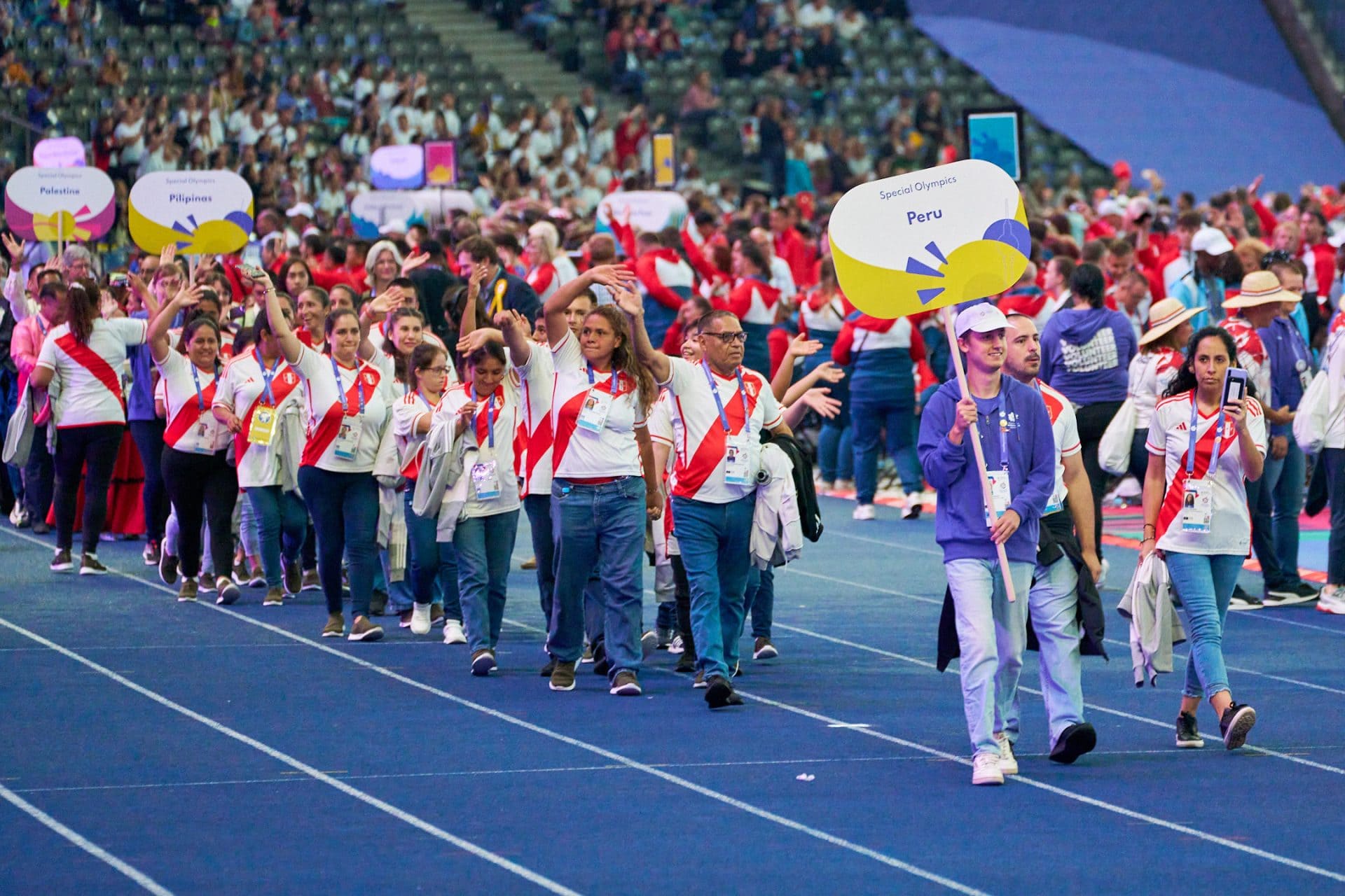 A diverse group of individuals walking together on a track, showcasing unity, teamwork, and physical activity.